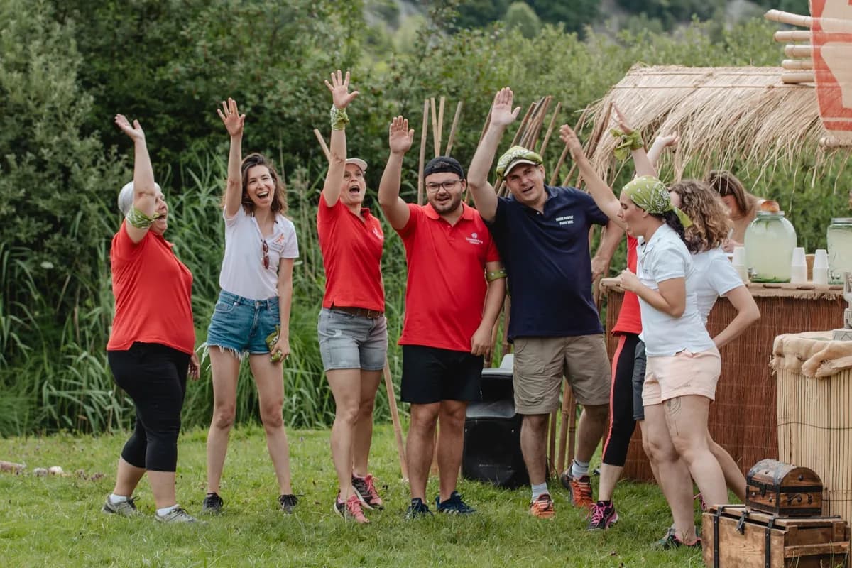 Team members cheering together outdoors during a group challenge