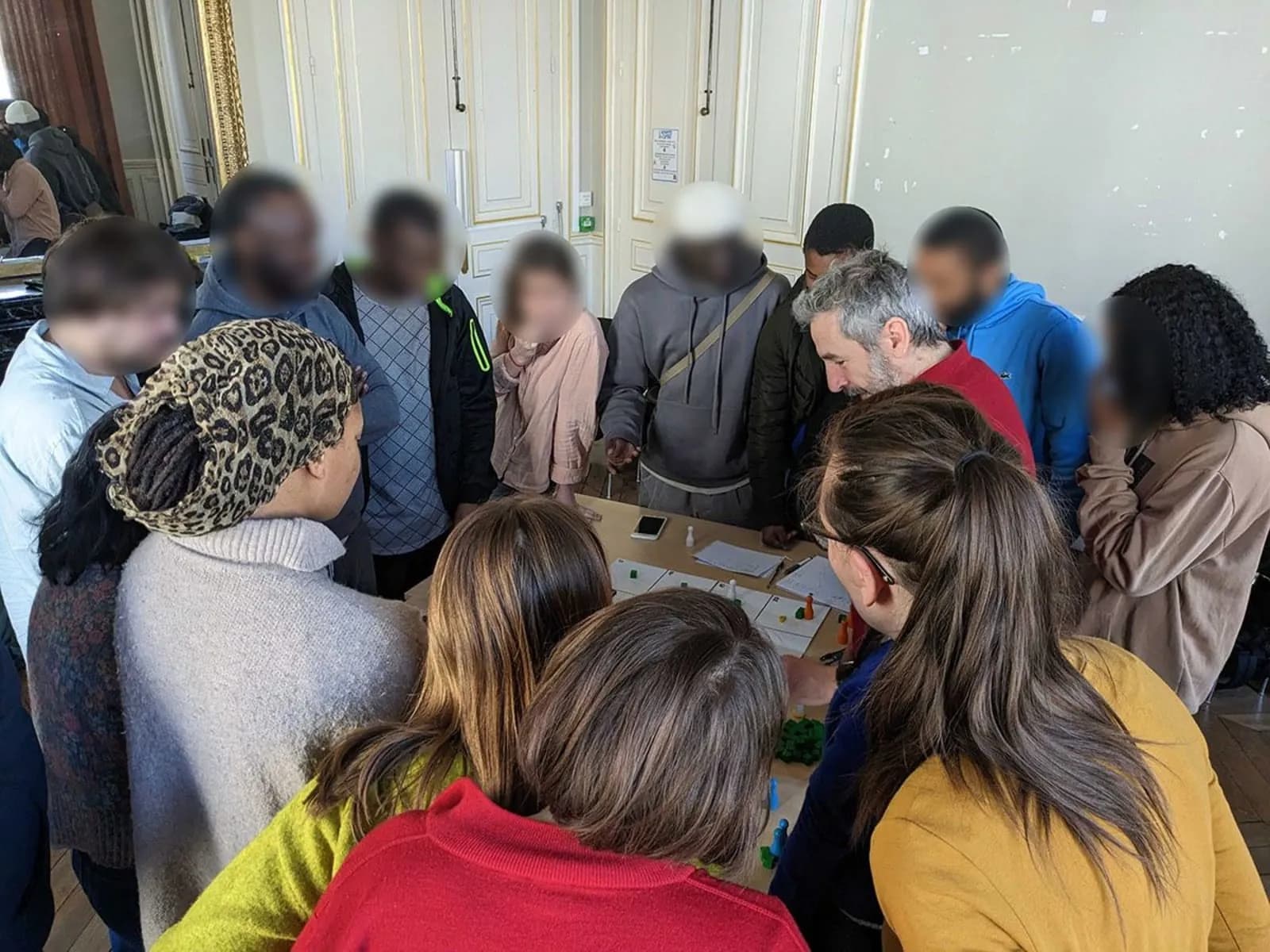 Team members working around a table during a collaborative game