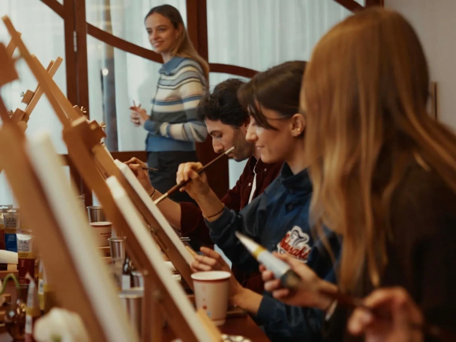 Team members painting artworks during a creative workshop in Paris