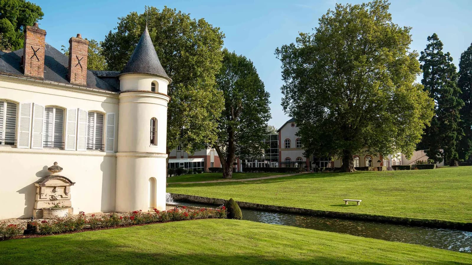 Château facade with a lawn and pond at Domaine des Hautes Clairières, Oise, north of Paris