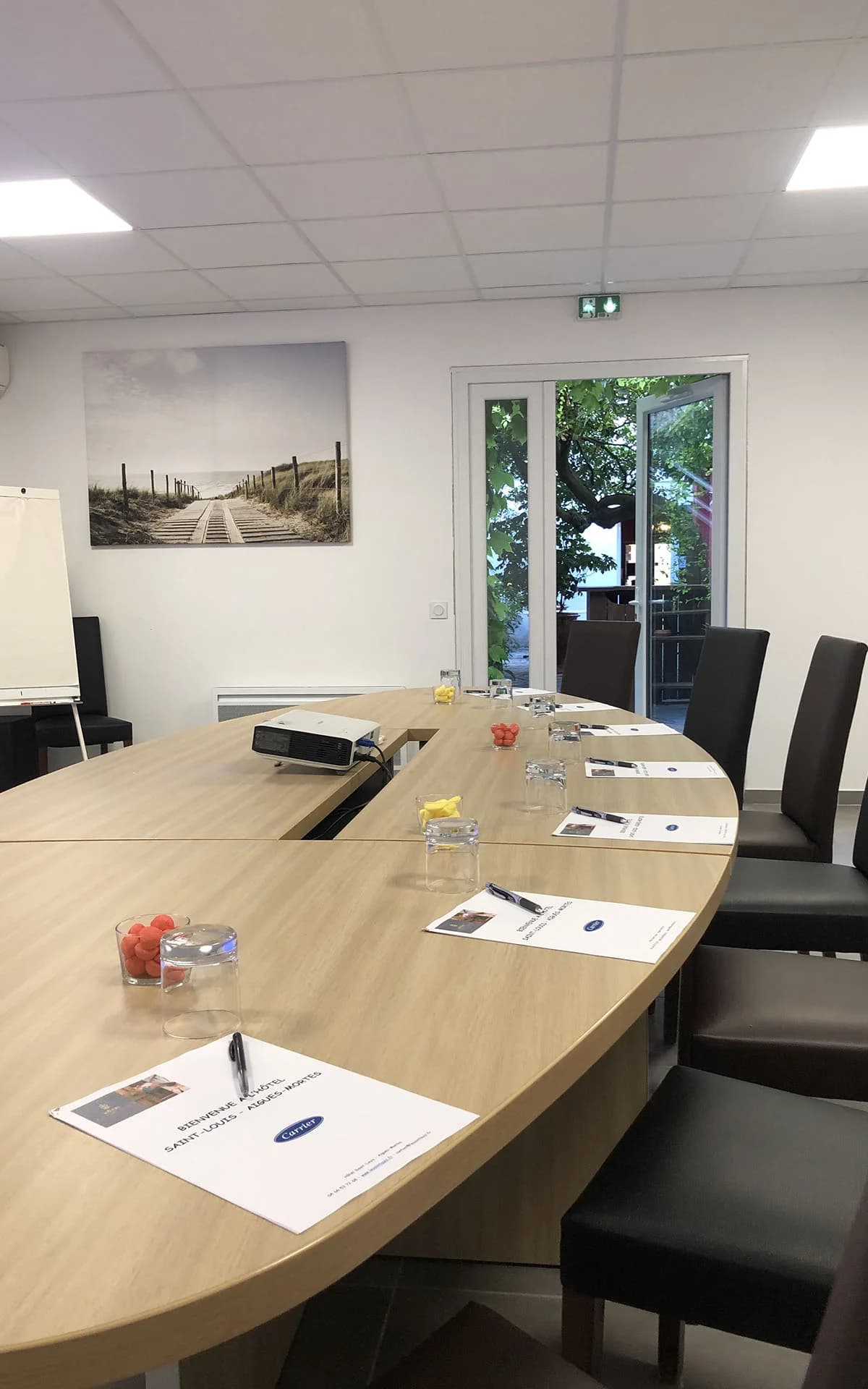 Meeting room at Hôtel Saint-Louis in Aigues-Mortes, with a large oval table, flipchart and projector