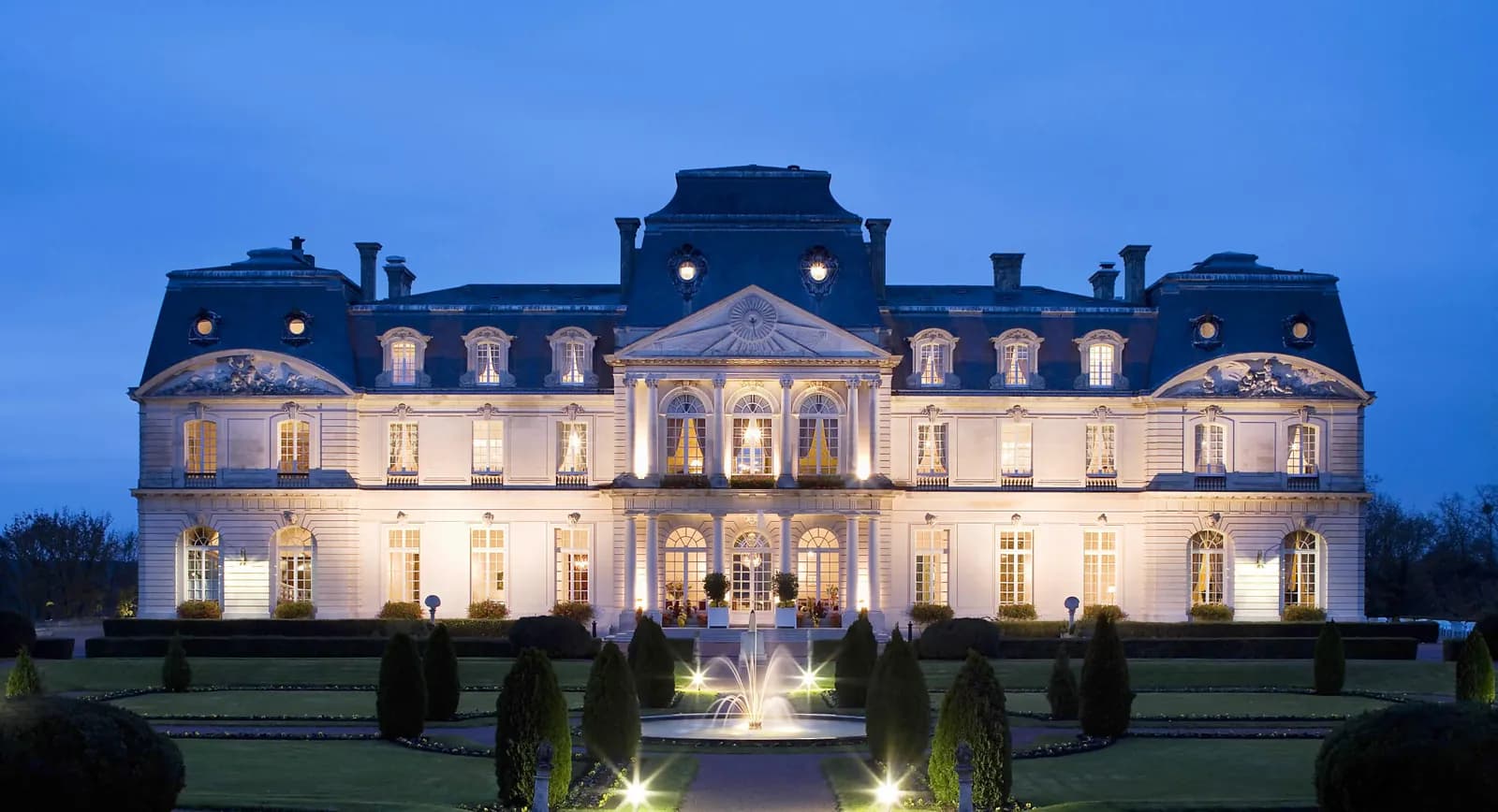 Château d'Artigny illuminated at dusk with its fountain and formal gardens, near Tours