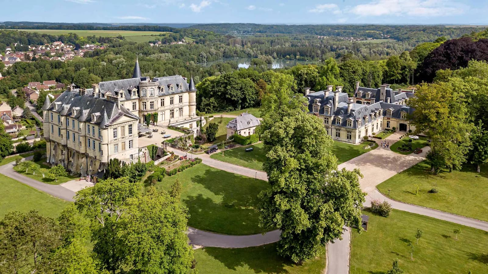 Aerial view of Château des Tourelles Blanches, a classical château set in a wooded park in the Oise