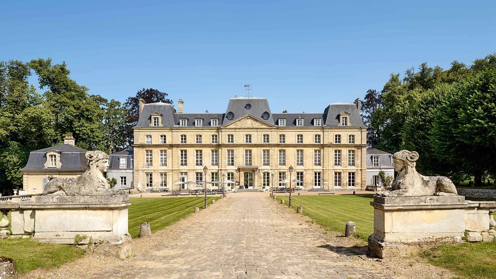 Château with stone lion statues and a gravel approach to the entrance at Château du Val Vert, Val-d'Oise