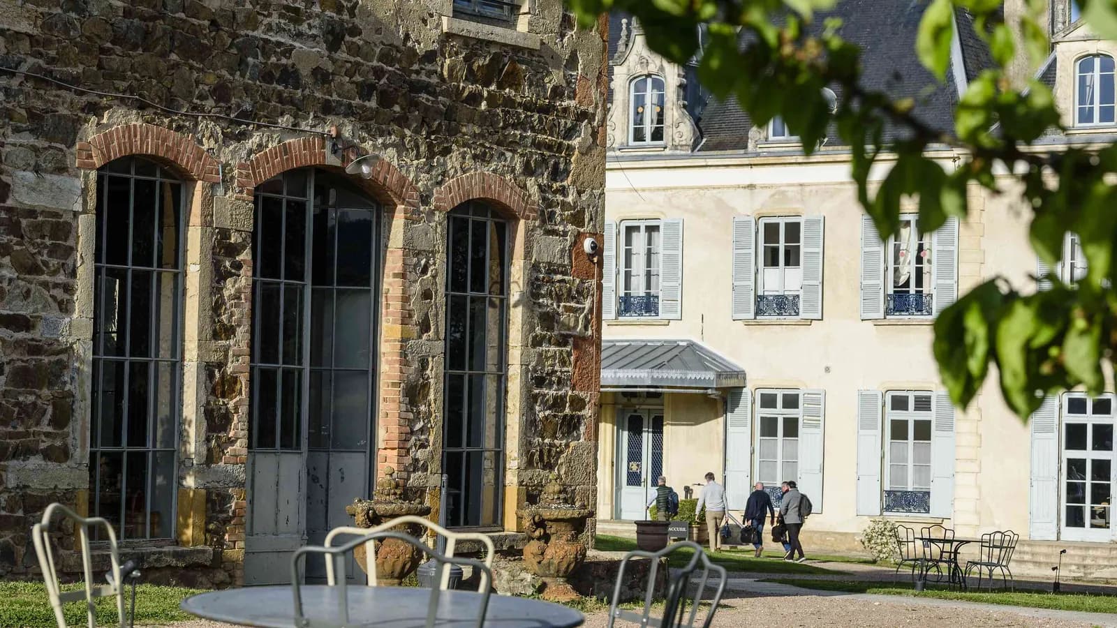 Stone building with arched windows and a fine stone courtyard at Demeure du Haut Beaujolais, Rhône