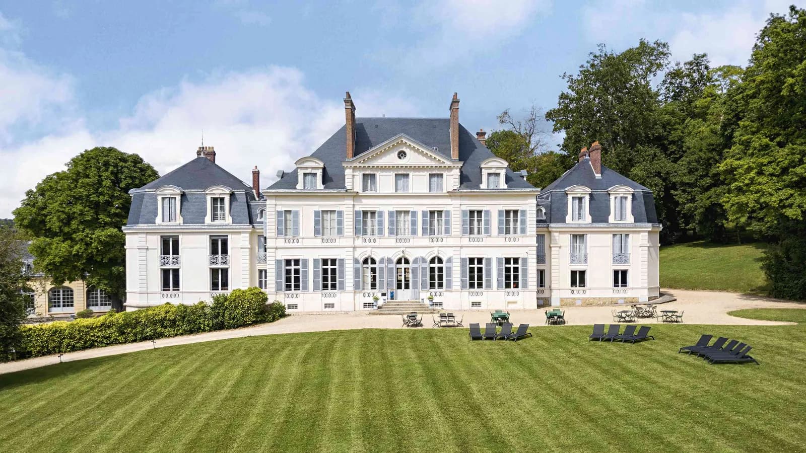 Château facade with manicured lawns and a formal approach at Domaine des Ormes Blancs, Seine-et-Marne