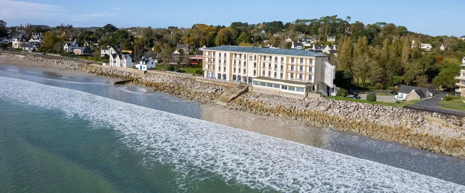 Aerial view of the seafront hotel above the rocky shore and surf at Hôtel des Rivages Argentés, Brittany