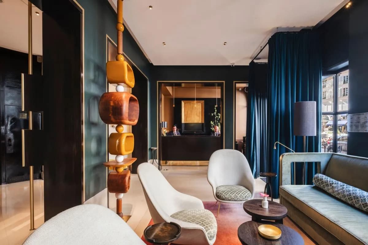 Lobby of Hôtel Montalembert Paris with a sculptural wooden light column and deep blue curtains in the 7th arrondissement