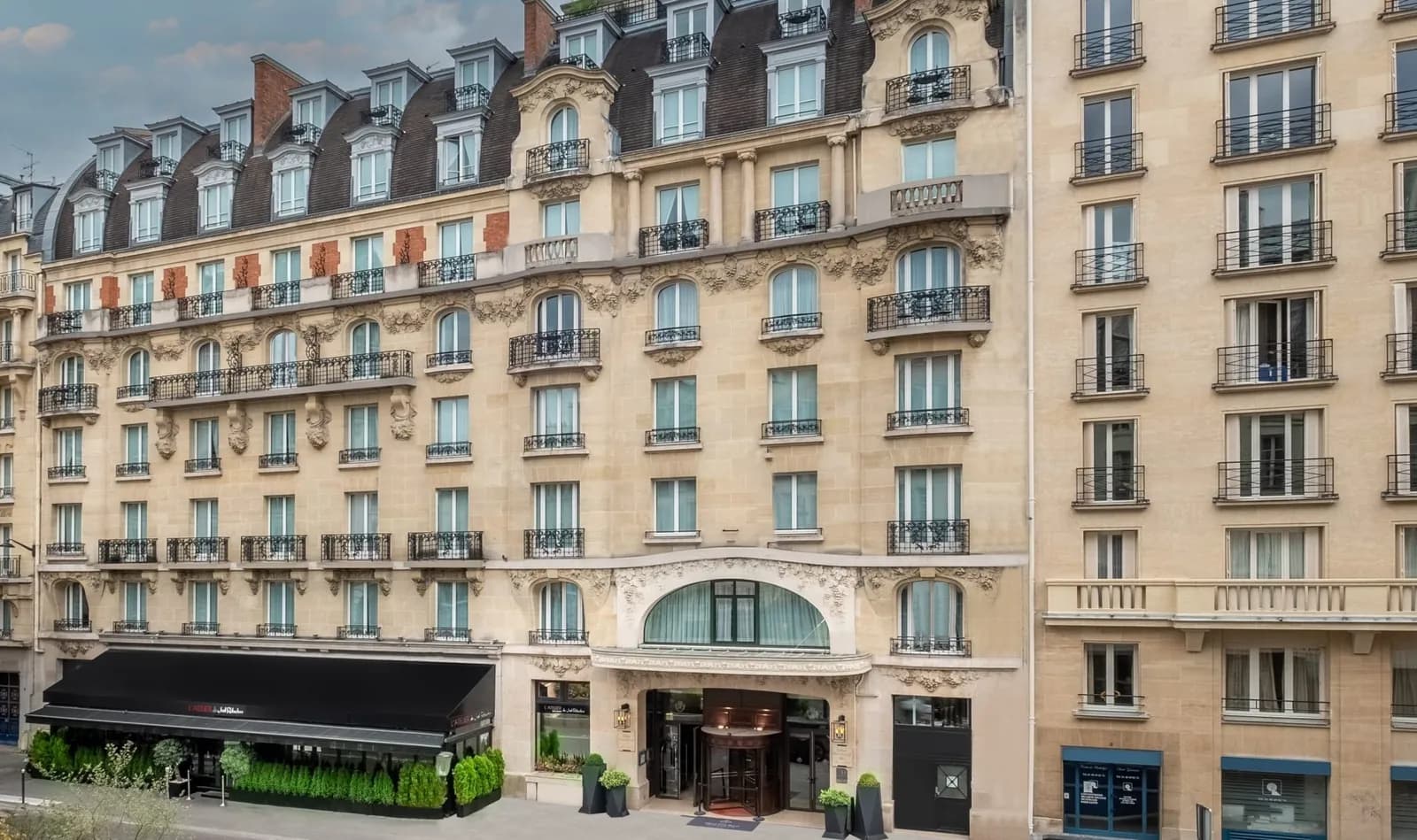 Street facade of Hôtel Pont-Royal in Paris's Saint-Germain district, with its dark awning and stone frontage