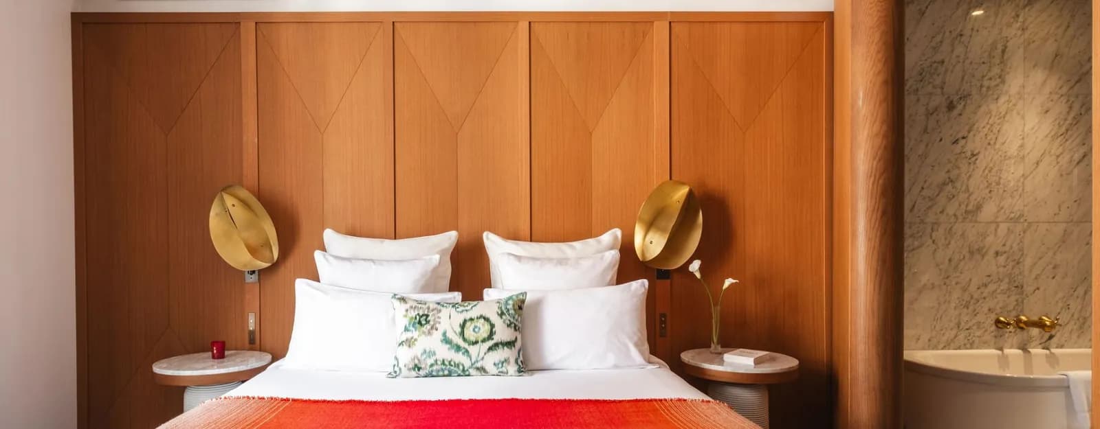 Bedroom at Hôtel Vernet in Paris, with a bed in warm wood-panelled décor and brass bedside lamps