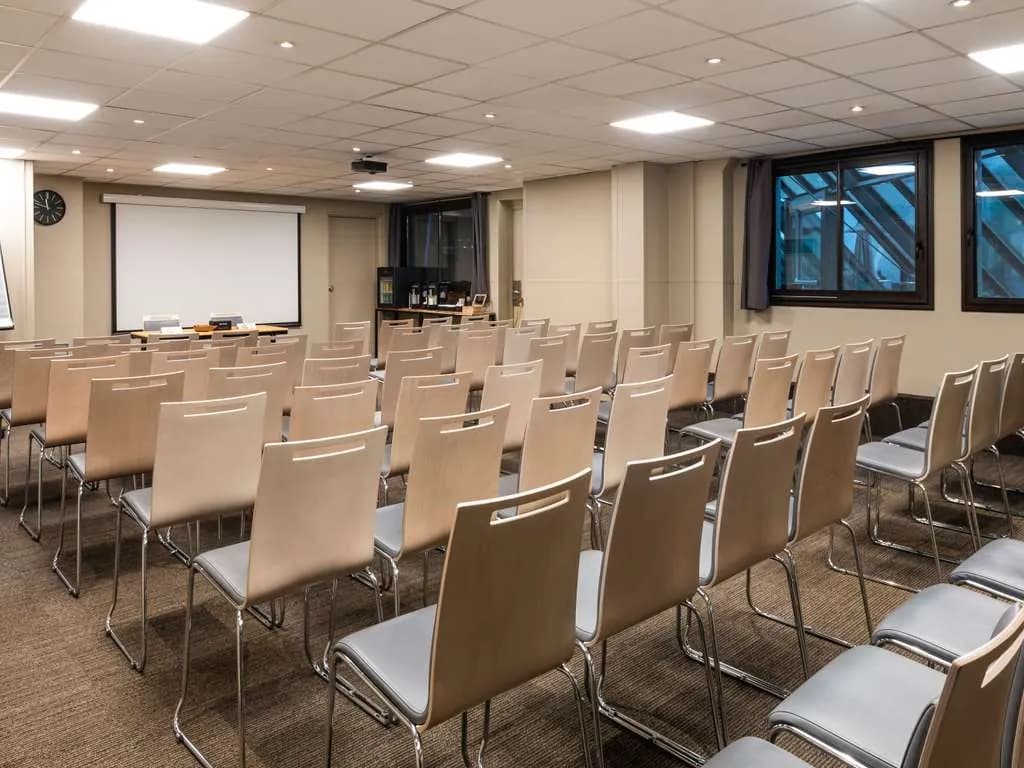 Meeting room set in classroom layout with a projection screen at ibis Paris Alésia Montparnasse, Paris 14th