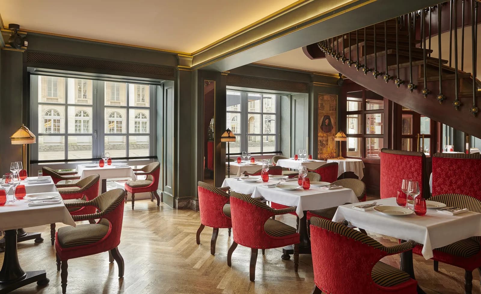 Le Bordeaux restaurant-bar with red armchairs and a sweeping staircase at InterContinental Bordeaux