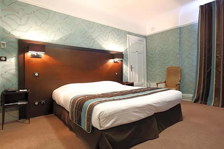 Double guest room with a patterned green wall, brown headboard and striped throw at Le Grand Hôtel Tours
