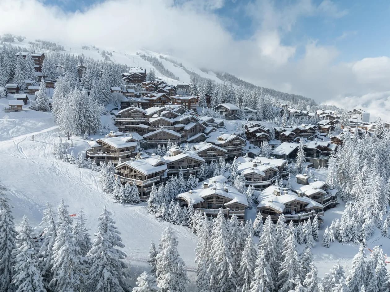 Aerial winter view of the snow-covered chalets of Courchevel 1850 around Le K2 Palace on the Jardin Alpin
