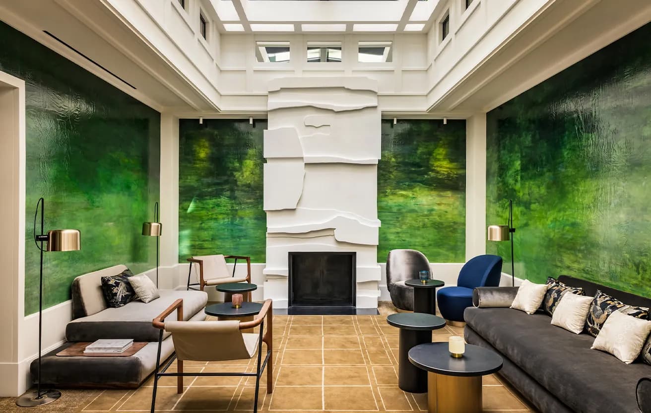 Lounge with green wallpaper, sofas and a fireplace at Le Pavillon de la Reine, Place des Vosges, Paris