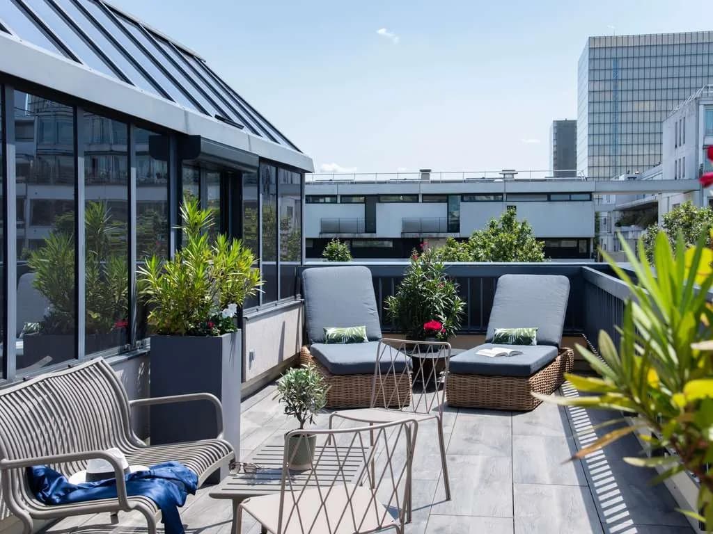 Rooftop terrace of Hôtel Mercure Paris Bercy Bibliothèque with lounge chairs, planters and city views
