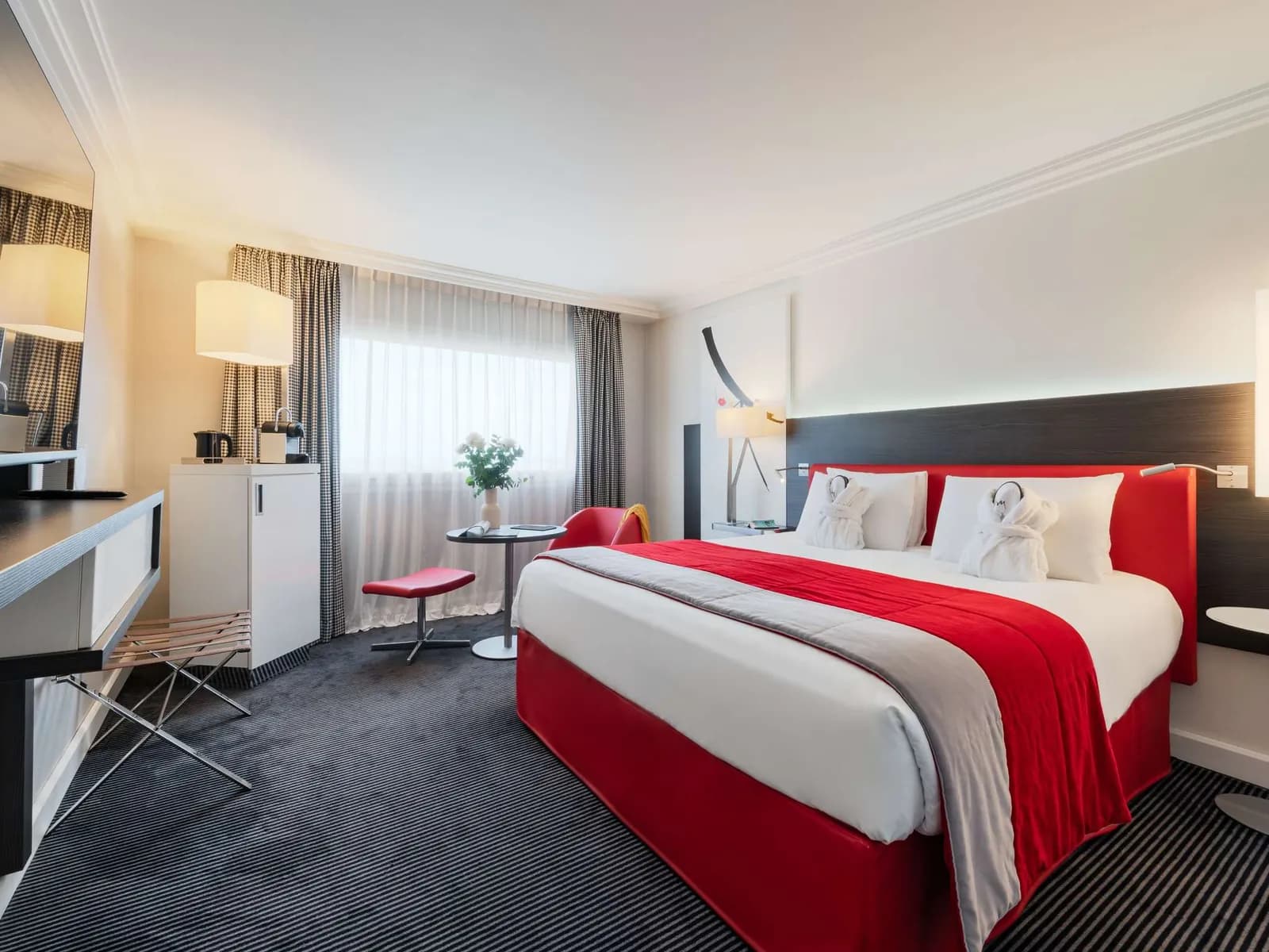 Guest room at Mercure Paris CDG Airport with a red and white bed, a desk and a bright window
