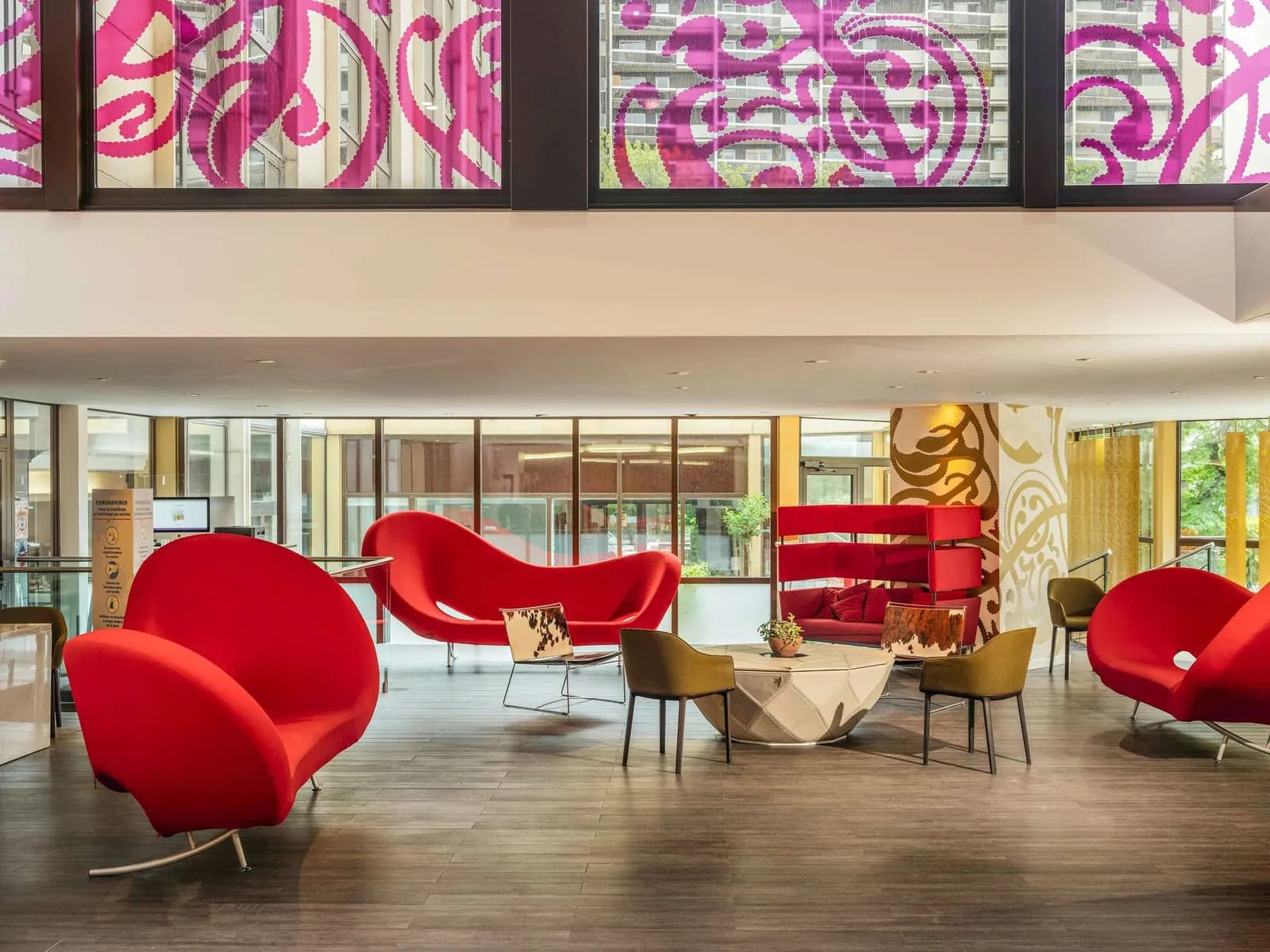 Lounge with red armchairs and a patterned wall at Mercure Paris Centre Tour Eiffel hotel, Paris