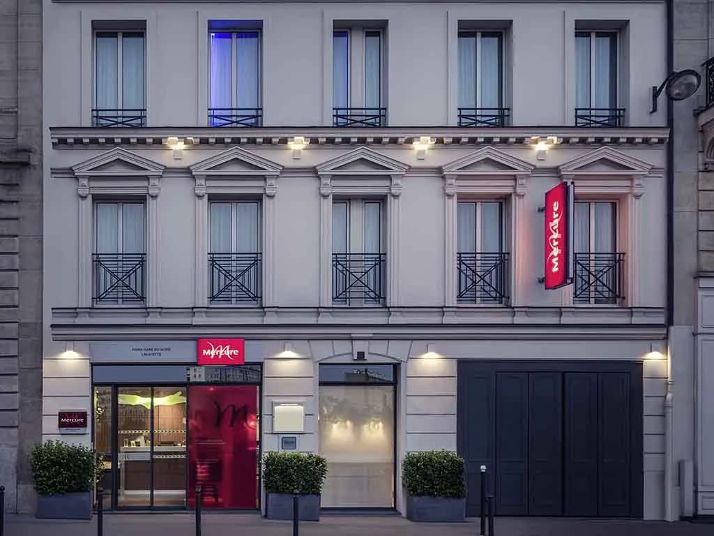 Street facade of Mercure Paris Gare du Nord La Fayette with its red sign and dark ground-floor entrance