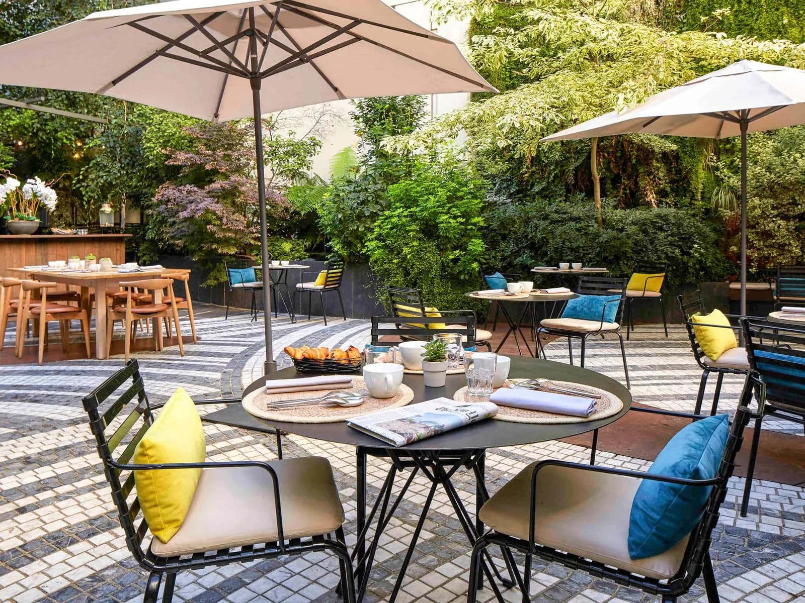 Terrace garden with parasols and a mosaic floor at Novotel Paris Les Halles, Paris 1er