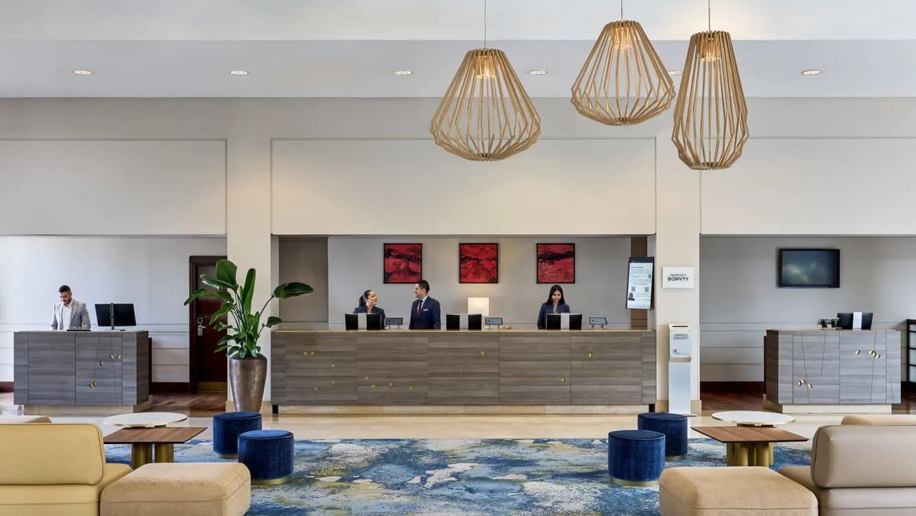 Reception desk and lobby of the Paris Marriott Charles de Gaulle Airport Hotel with pendant lights