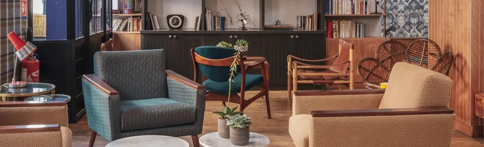 Piapia Hotel Paris lounge with vintage armchairs, a bookshelf wall and warm wooden floors