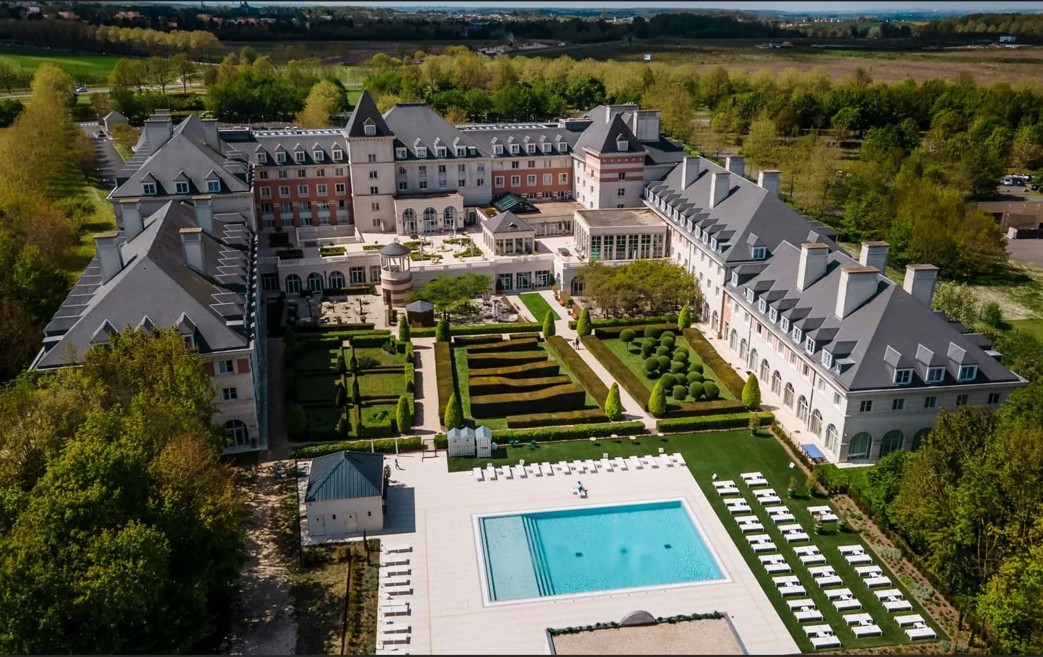 Aerial view of Vienna House Dream Castle Paris, its château-style building and formal gardens