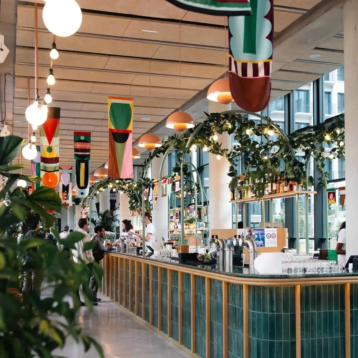 Art Deco brasserie interior with a long bar and plants