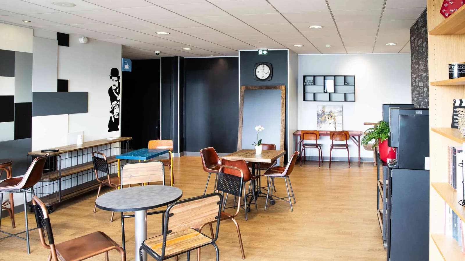 Northern Workshops break area with bar stools, round tables and a colourful wall graphic