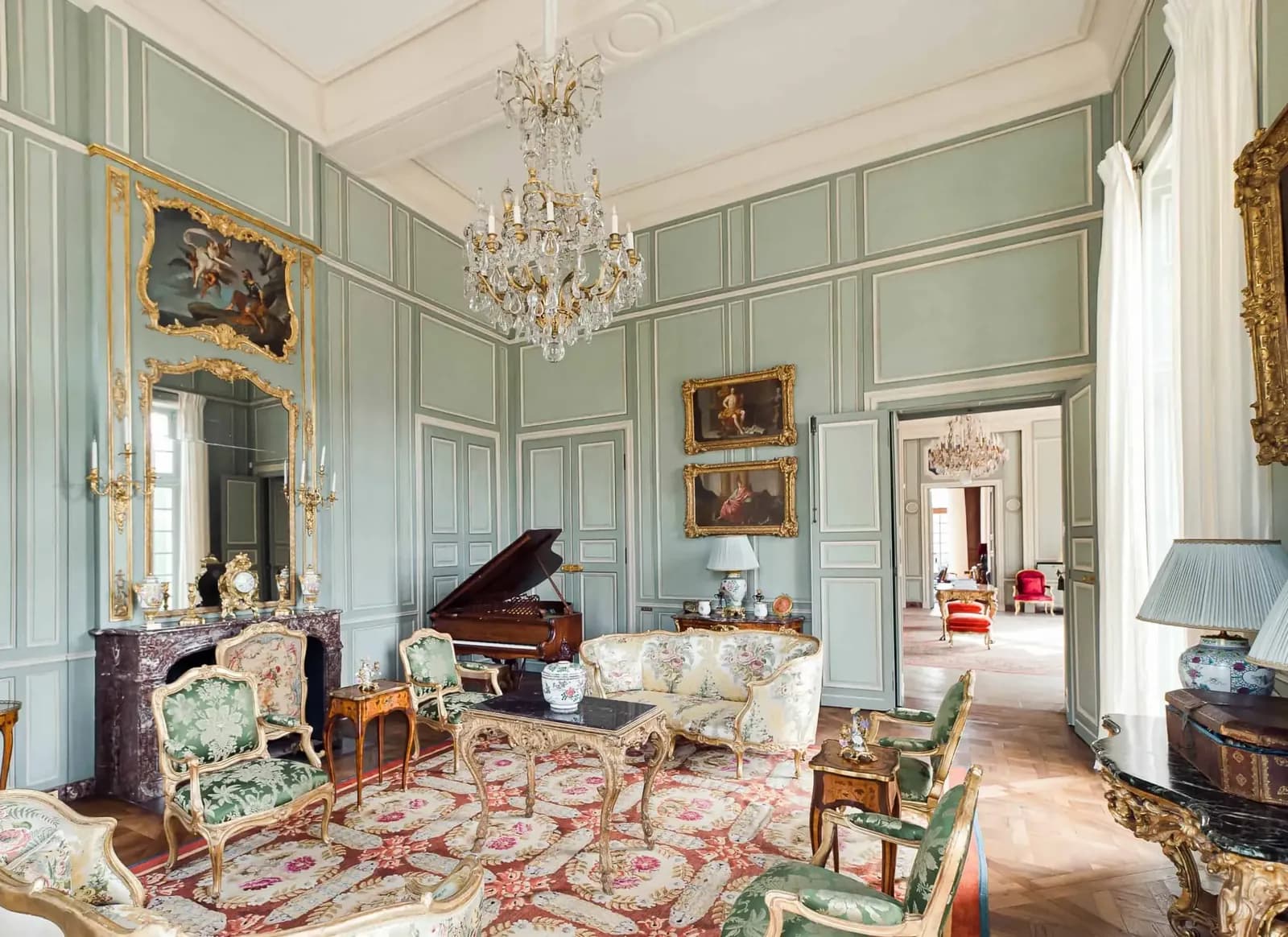 Château salon with chandeliers, period furniture and a patterned rug