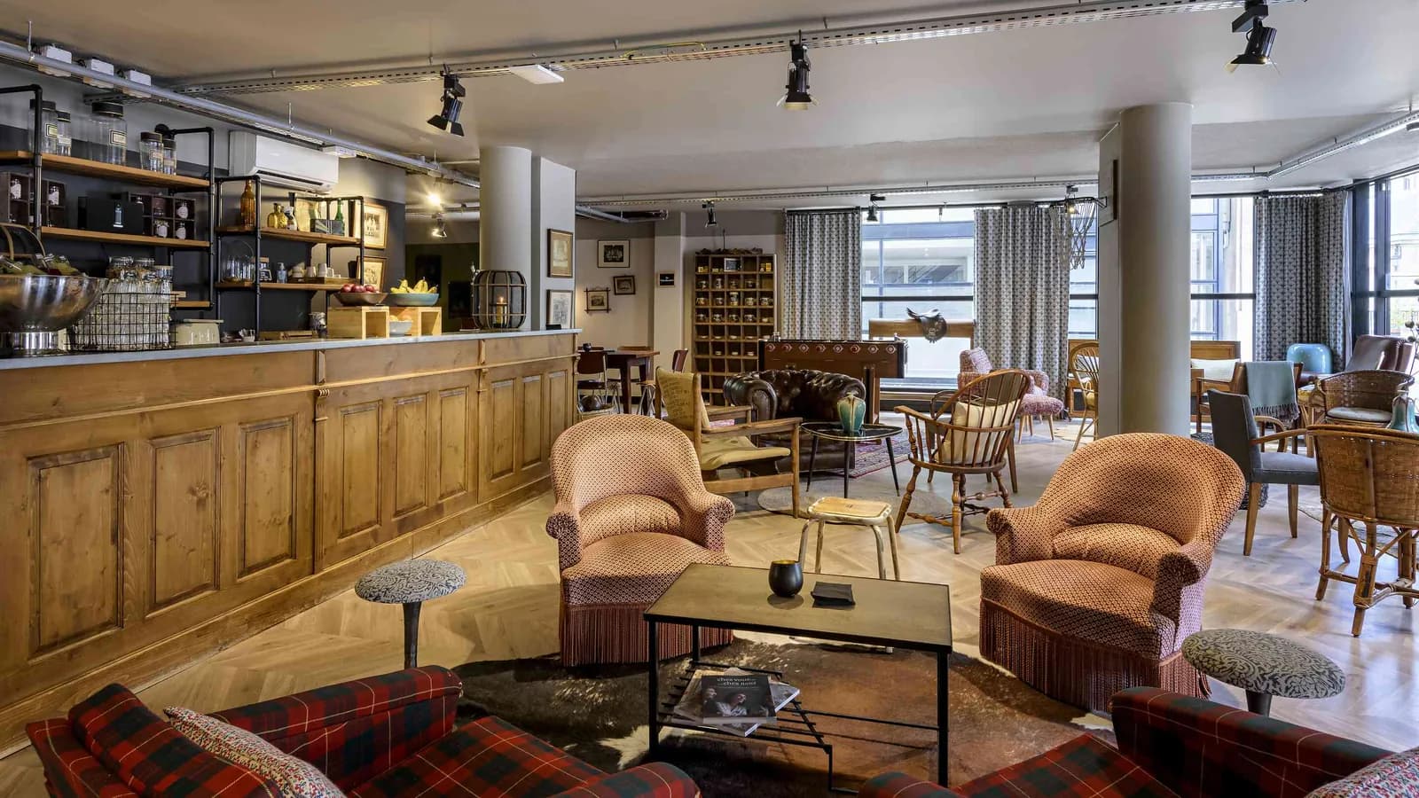 Workshop House lounge bar with leather armchairs, a wooden counter and vintage lamps
