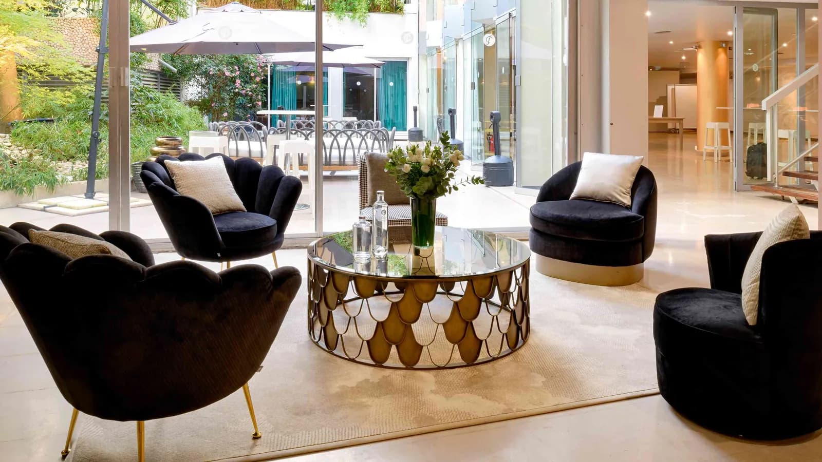 Golden House lounge with black velvet armchairs, a gilded marble table and garden view