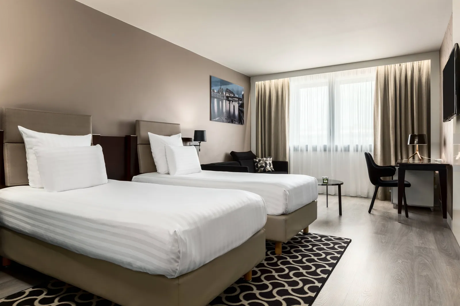Twin guest room at AC Hotel by Marriott Paris Porte Maillot, with a work desk and wooden flooring in Paris