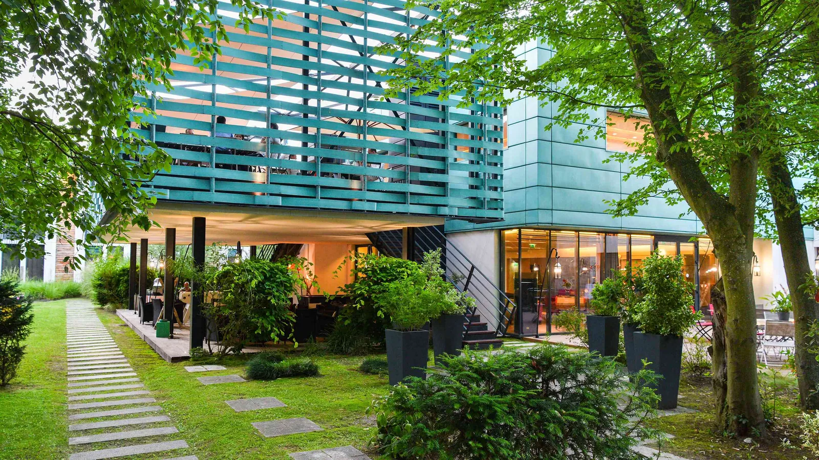 Contemporary wing of Château des Rives Claires with a glass facade and landscaped garden