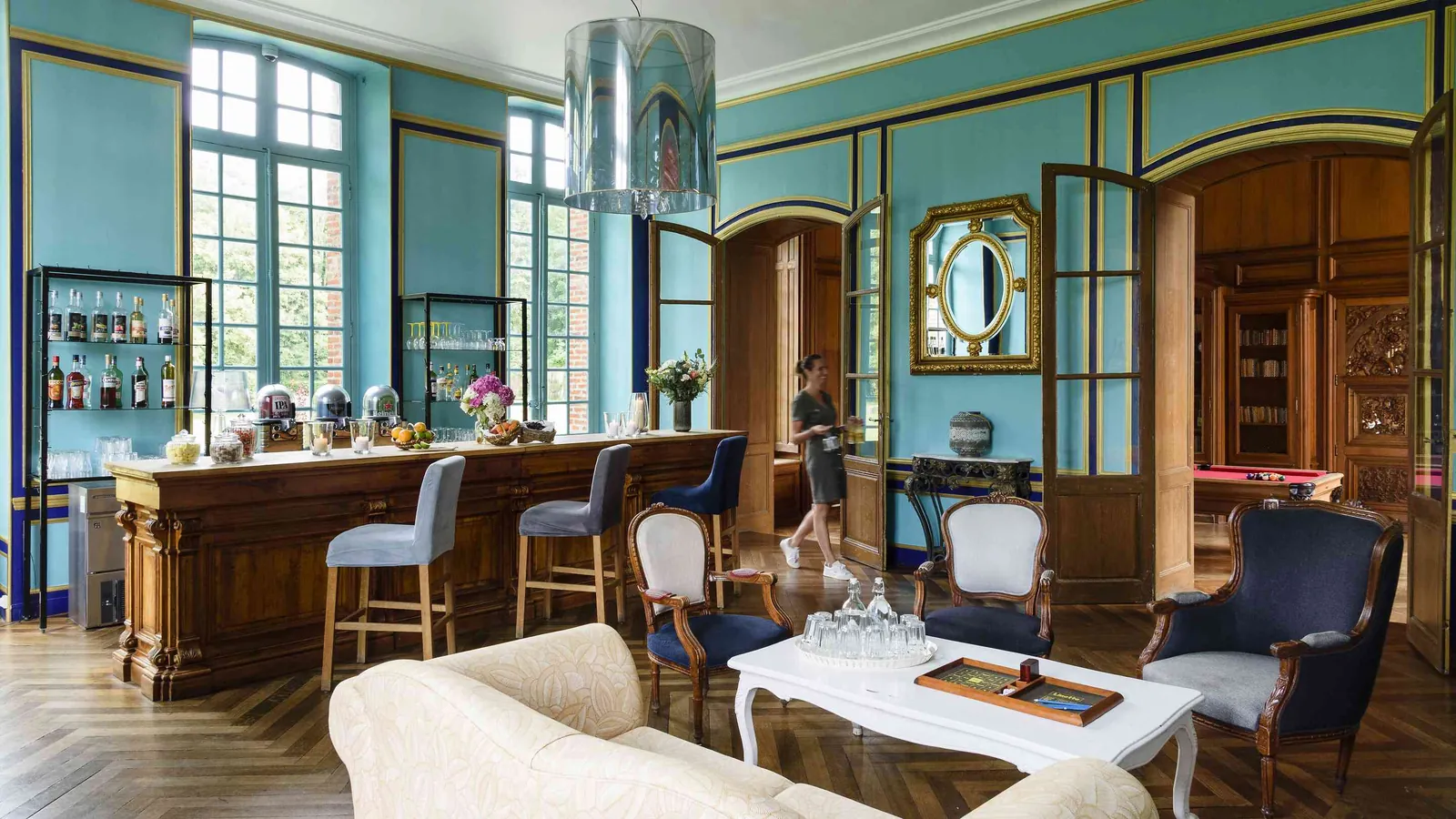 Blue-walled bar lounge with a wooden counter and billiard table at Demeure des Pommiers Roses, Eure