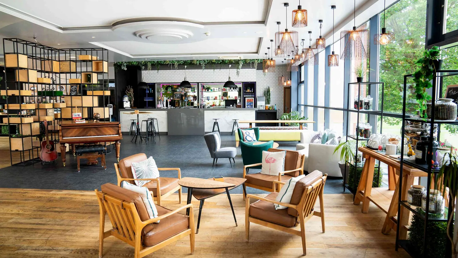 Lounge with armchairs, open shelving and natural light at Domaine des Hautes Clairières, Oise
