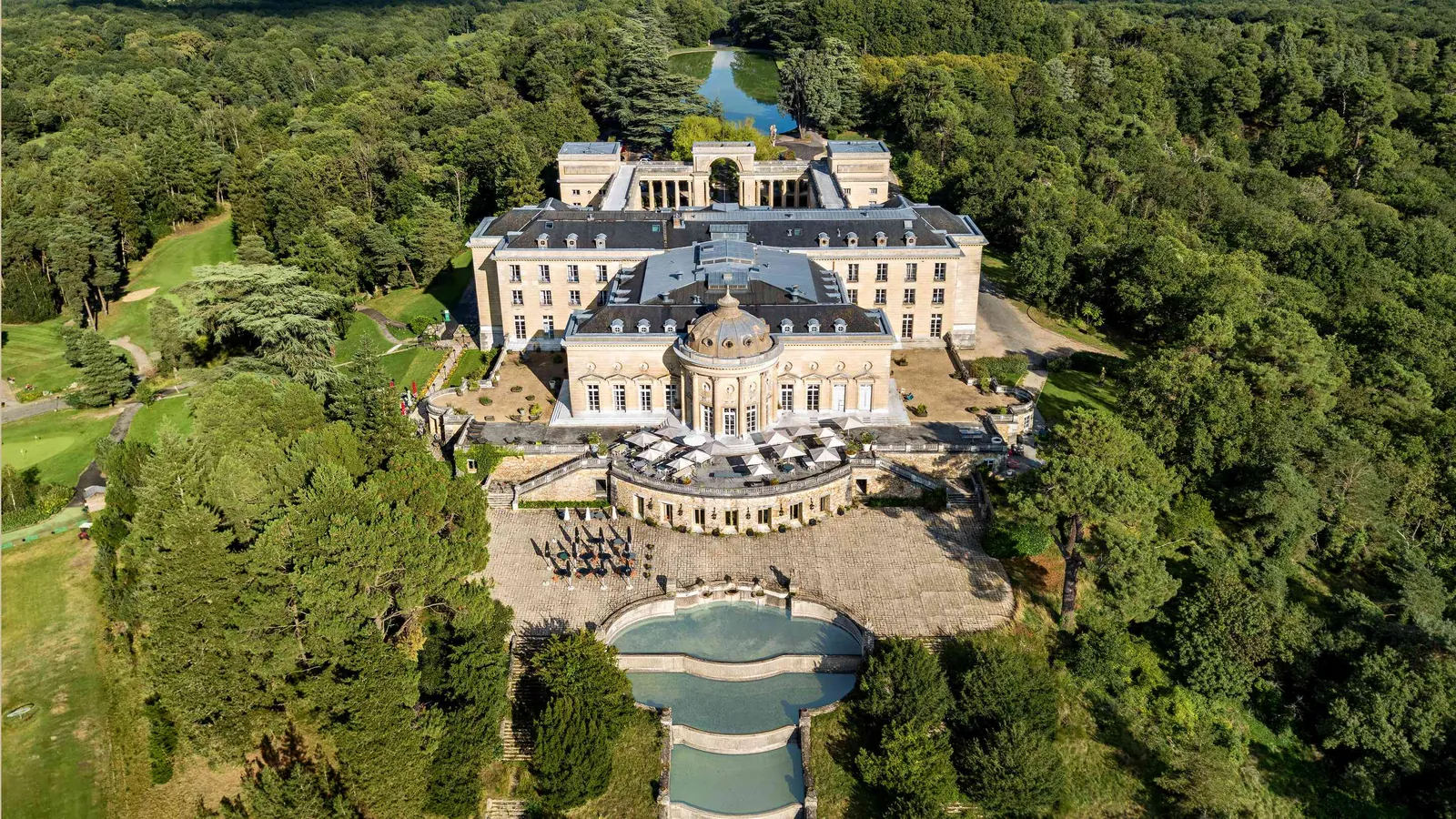 Château and formal gardens of Domaine des Hauts Chênes seen from above, with a water basin