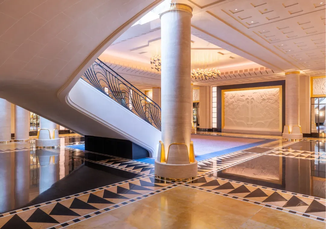Normandie lounge of the Hôtel du Collectionneur with a stone column, marble floor and Art Deco patterns