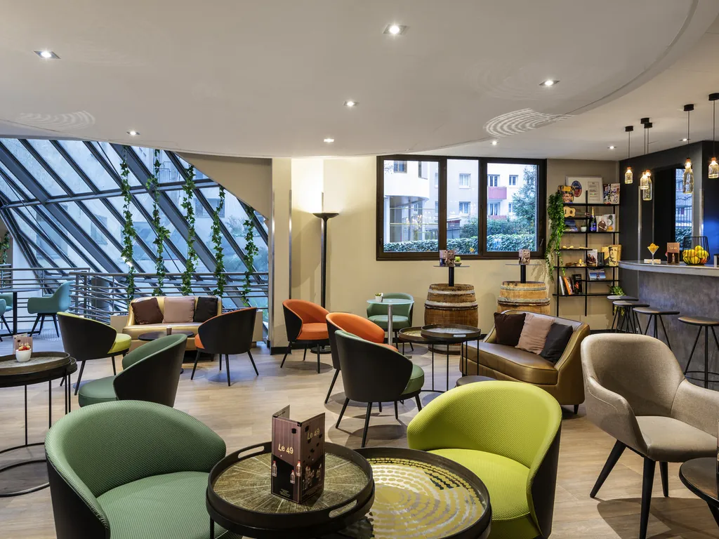 Lounge bar with green armchairs and a glass roof at ibis Paris Alésia Montparnasse, Paris