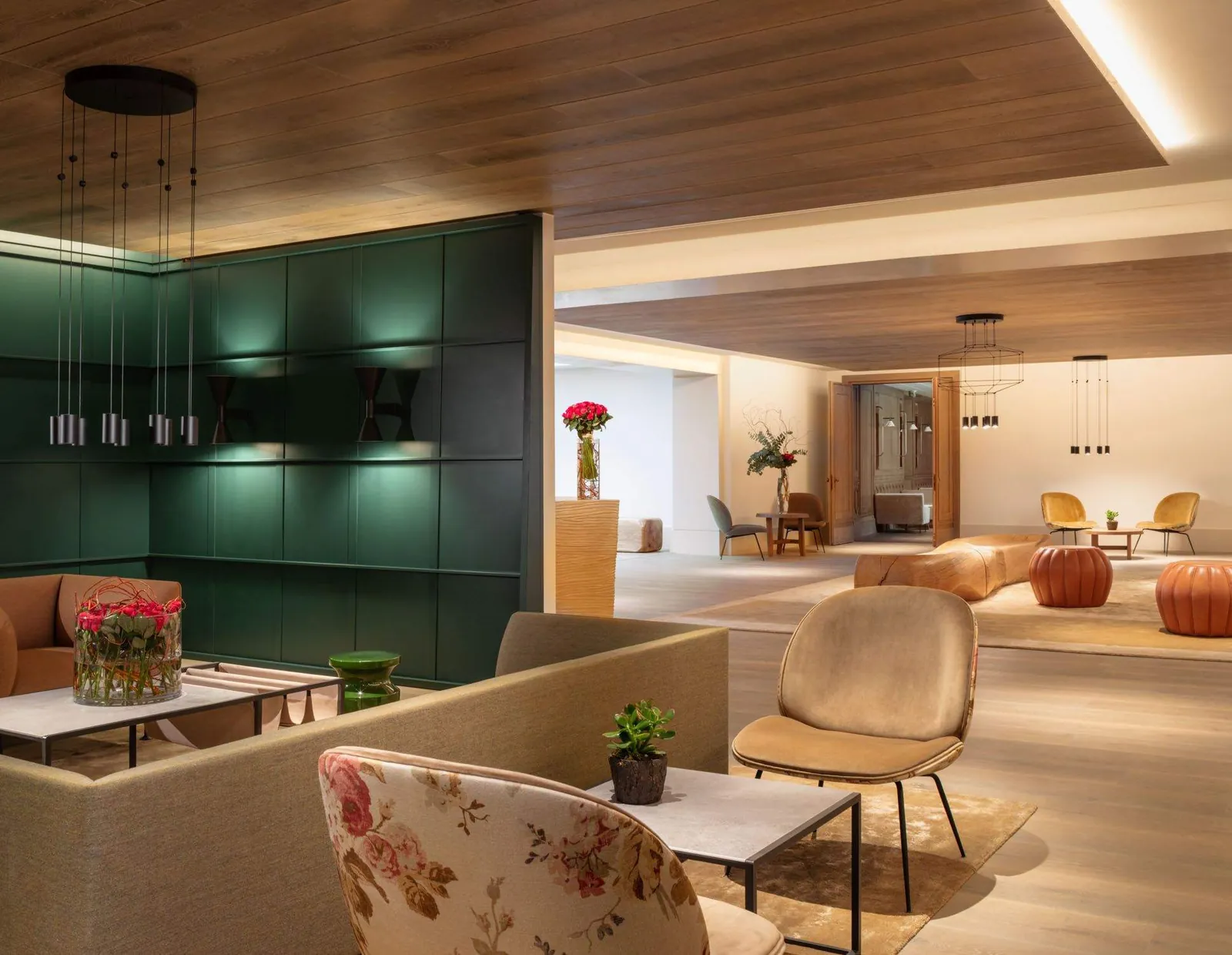 Lounge area at Le Grand Pavillon Chantilly with green cabinetry, armchairs and a warm wooden ceiling