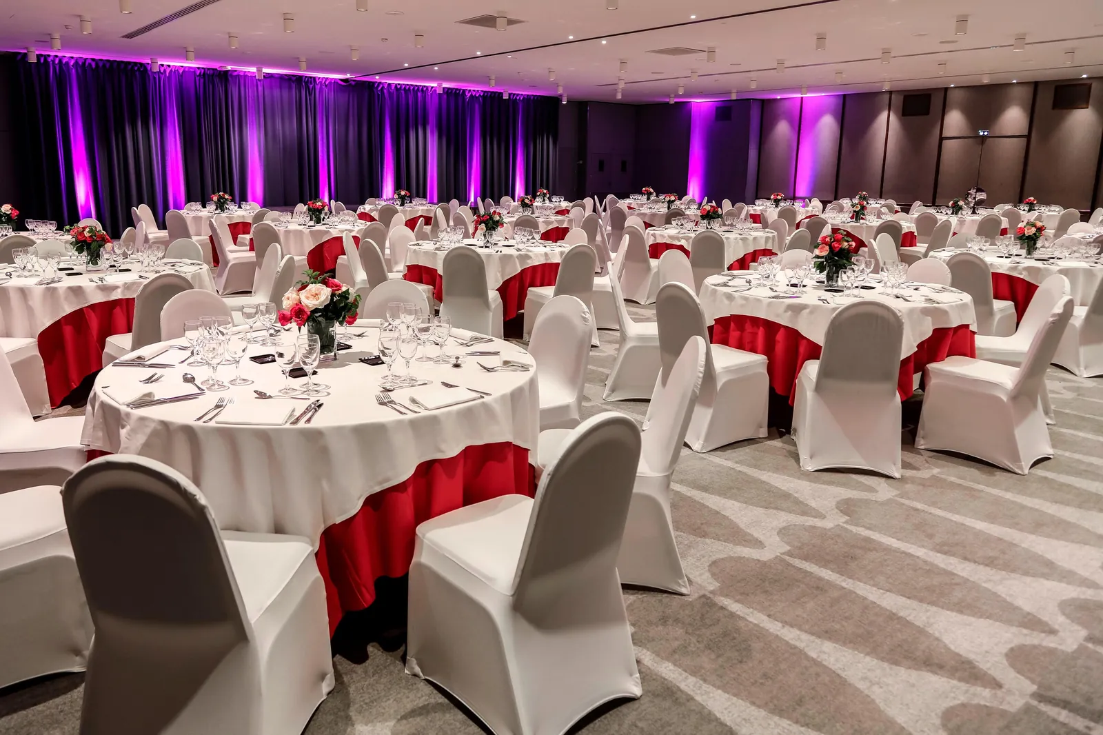 Gala dinner set with round tables, white linens and red drapes at Le Méridien Étoile, Paris