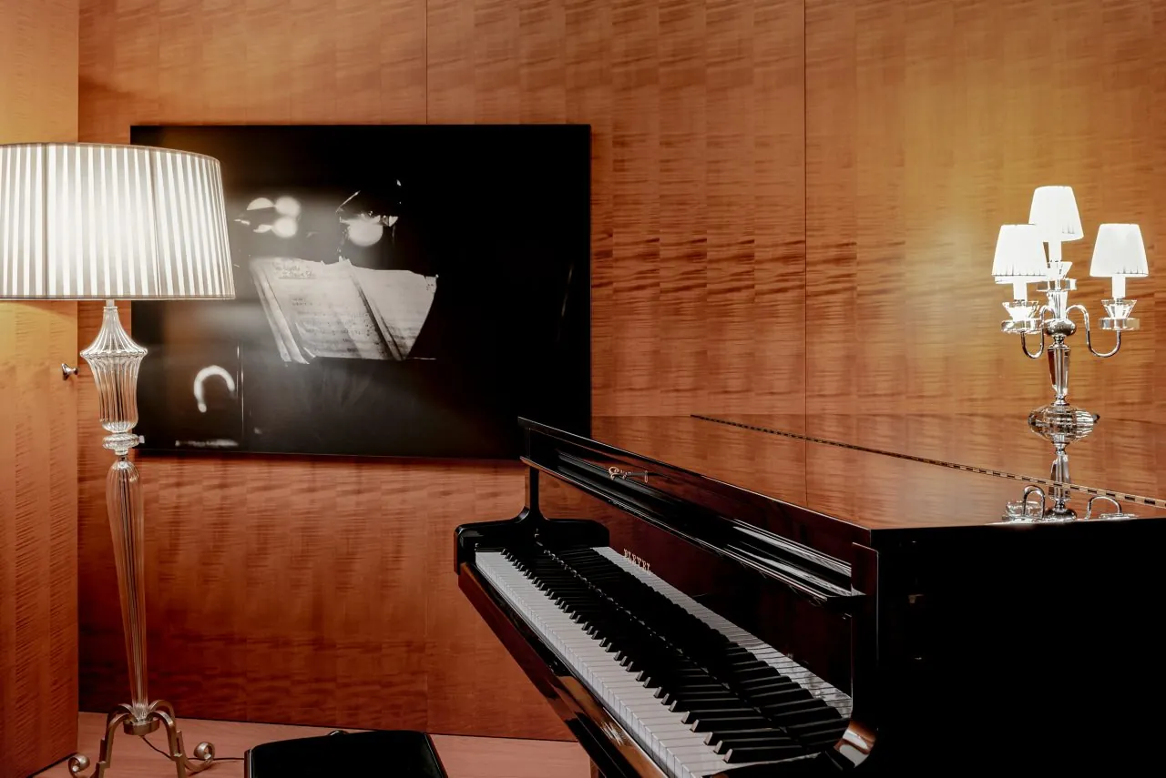 Piano lounge at Le Royal Monceau Raffles Paris with a black grand piano and crystal candelabra