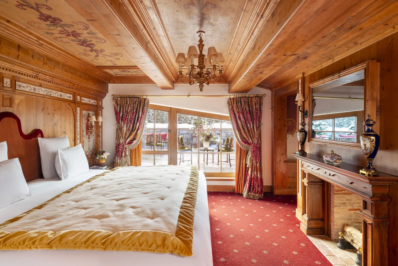 Chalet-style bedroom with carved wood panelling and a fur throw at Les Airelles Courchevel
