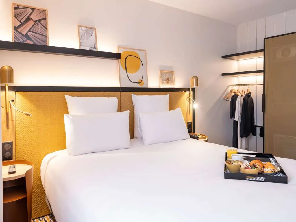 Lounge of Hôtel Mercure Paris Bercy Bibliothèque with bookshelves, a leather armchair and a tartan rug
