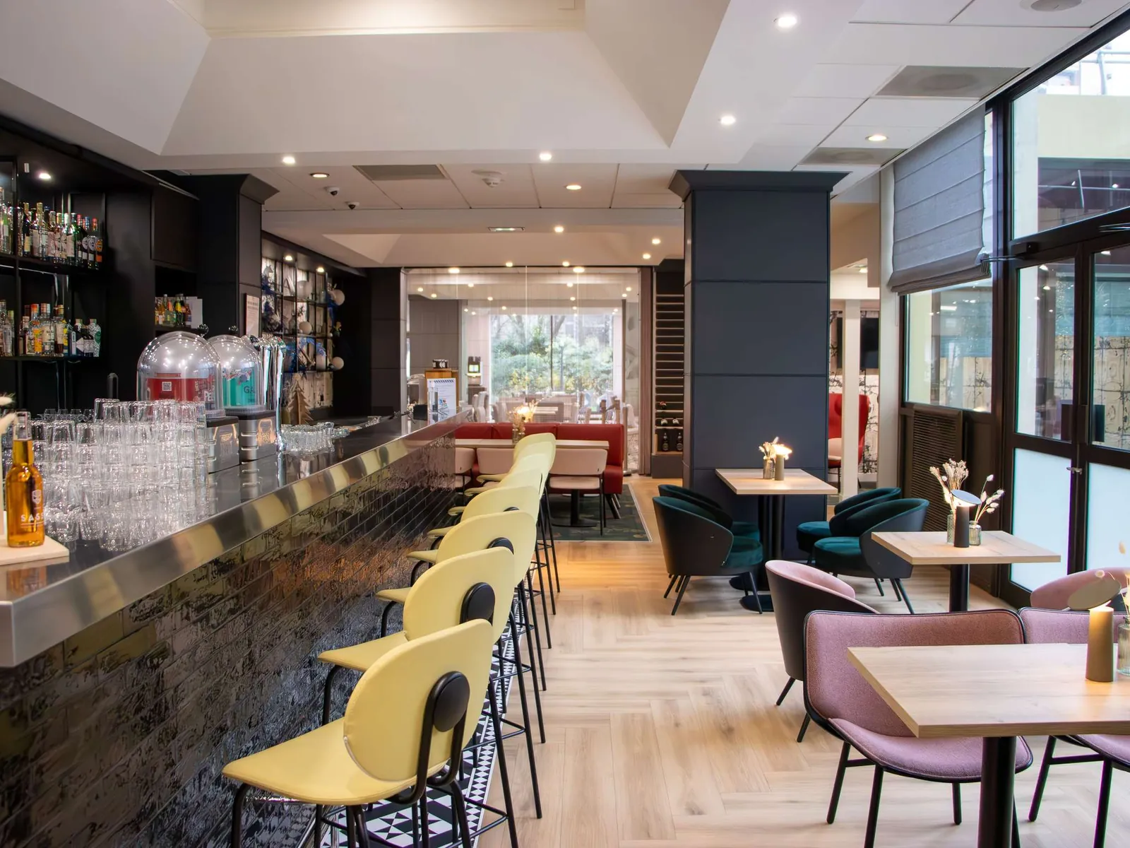 Bar counter with yellow stools and pink lounge seating at Mercure Paris Centre Tour Eiffel hotel