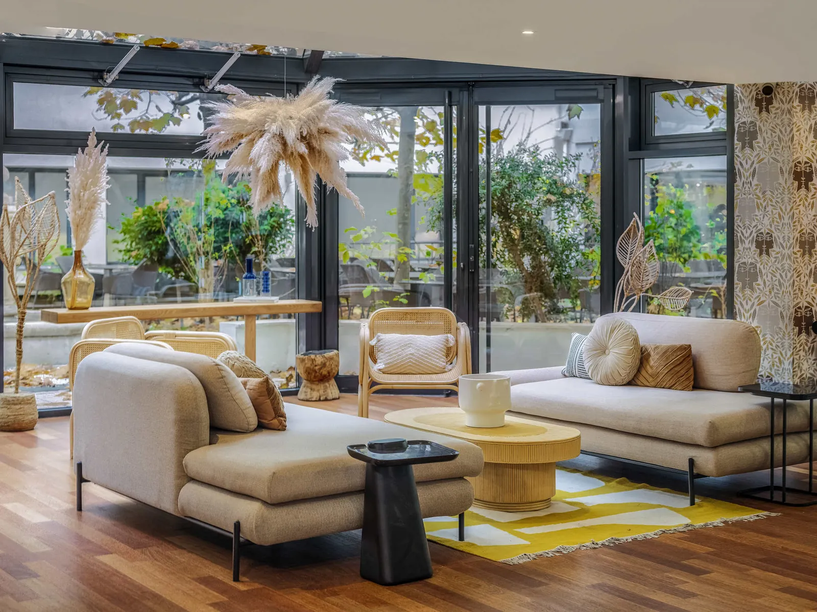 Lounge with a yellow rug, sofas and wooden tables at Mercure Paris Gare Montparnasse TGV, Paris