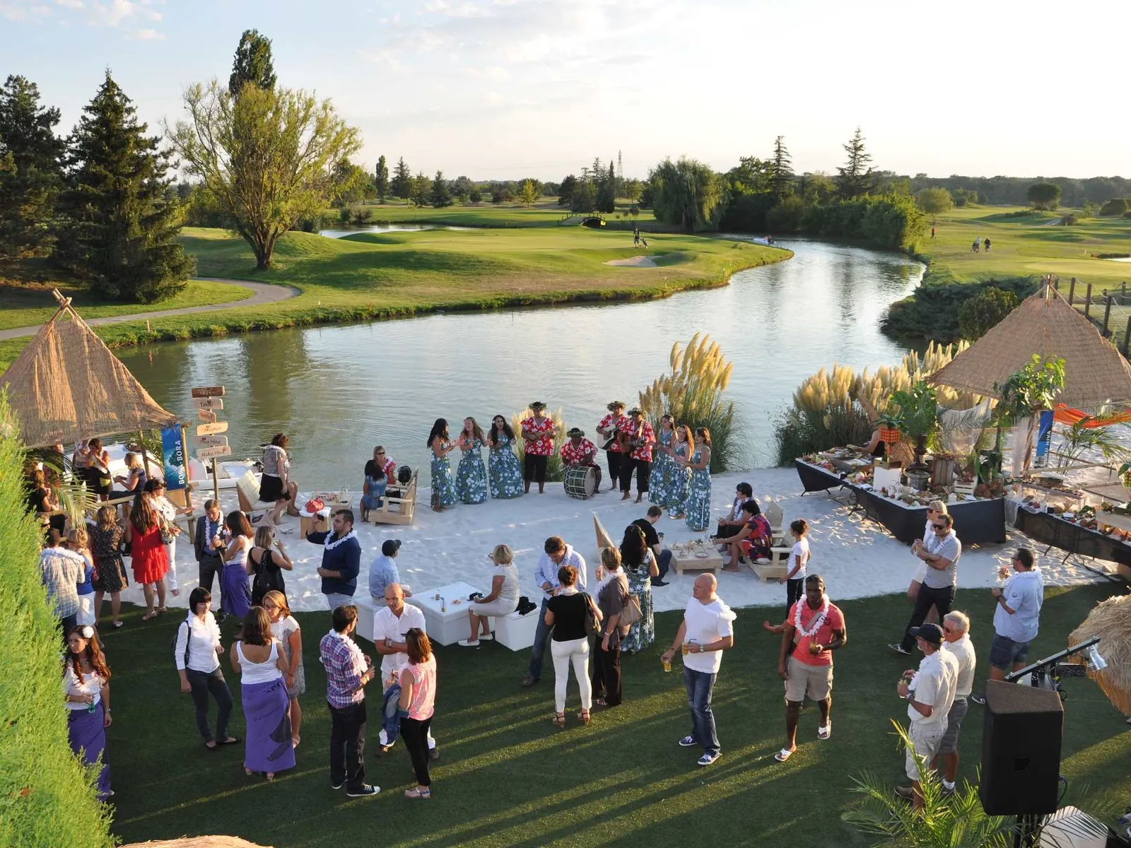 Outdoor evening reception on the lawn beside a pond at Mercure Toulouse Aéroport Golf de Seilh