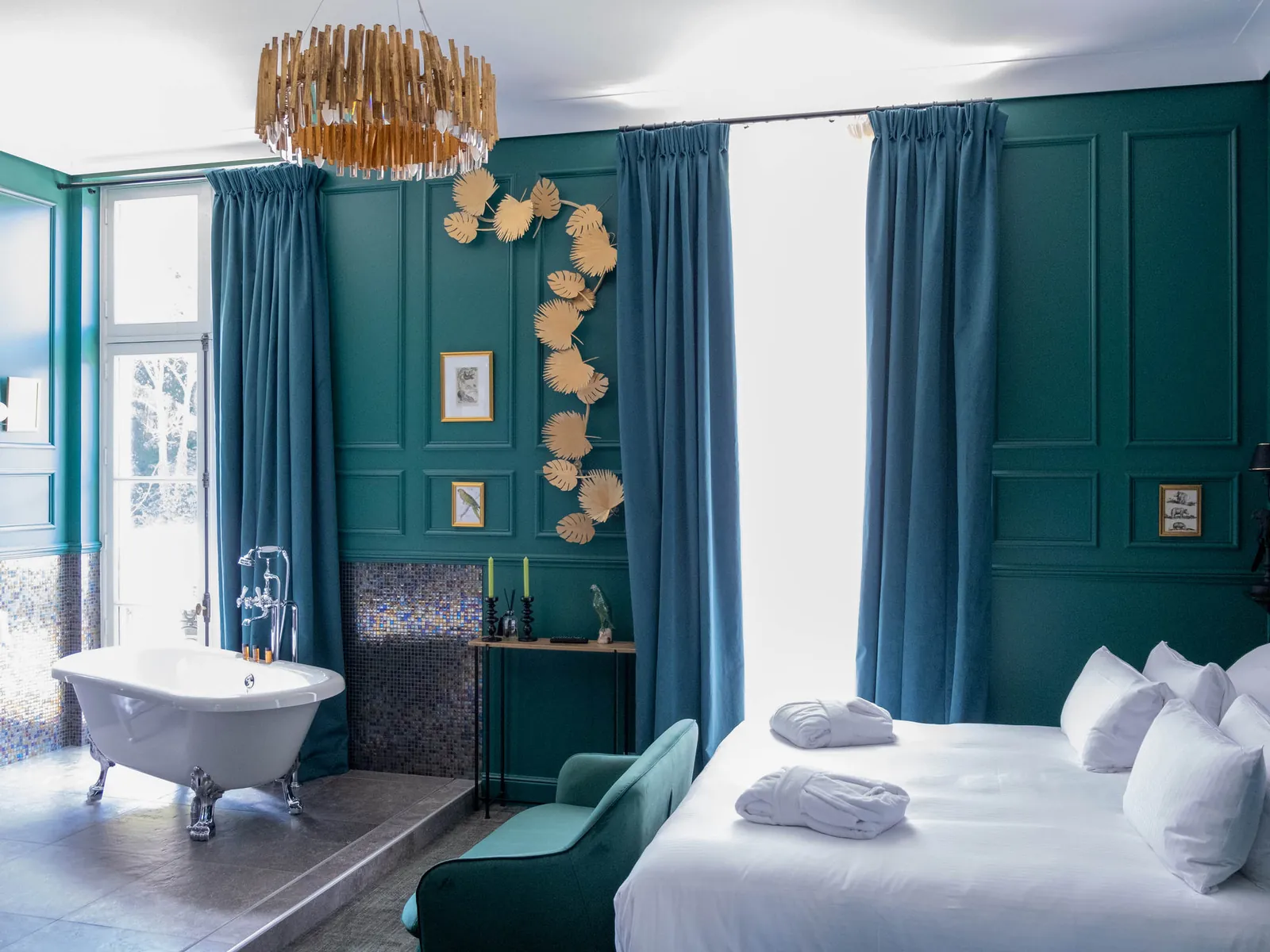 Bathroom suite at the Novotel Domaine de Maffliers with teal walls, a clawfoot bath and a king bed
