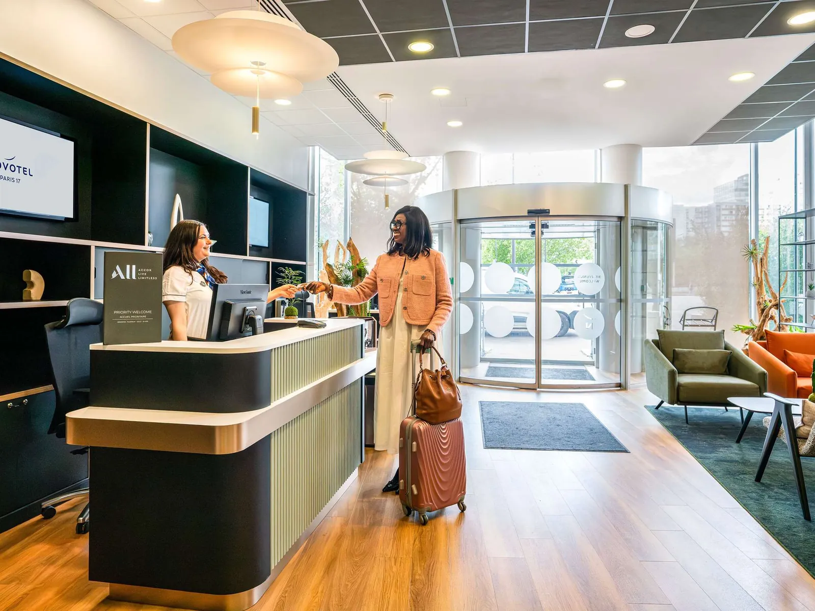 Reception area of Novotel Paris 17 with the front desk, lounge seating and wooden floors in Paris 17e