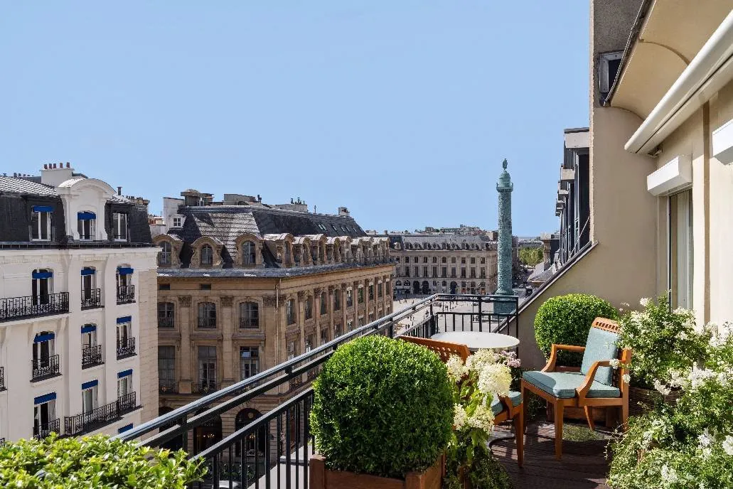 Terrace of the Park Hyatt Paris-Vendome with planters and a view of the Vendome Column above the Parisian rooftops